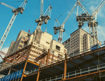 A group of professionals collaborating around a table with charts and technology devices, representing the strategic discussions and technological integration in the trading and contracting industry in Kuwait. This image mirrors the themes of networking, technology, and strategic planning discussed in the blog by Zenith Group.